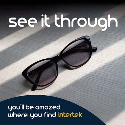 A pair of sunglasses on a table covered by shadows from a window blind